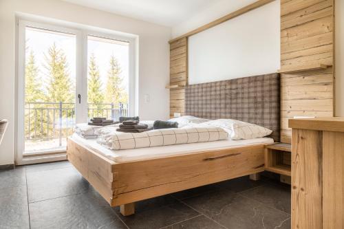 een slaapkamer met een groot bed en een groot raam bij Taurachhof Astlehen in Plankenau