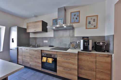 - une cuisine avec des placards en bois et une cuisinière dans l'établissement COTE MONTAGNE, à Munster