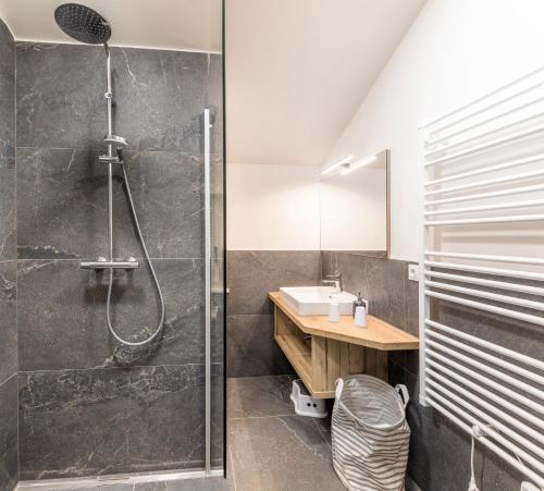 ein Bad mit einer Dusche und einem Waschbecken in der Unterkunft Taurachhof Astlehen in Plankenau