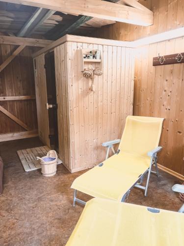 a room with two chairs and a wall with wooden walls at Naturnahes Familienchalet mit Garten - Wifi - Netflix - nur 15 Minuten vom Chiemsee und 35 Minuten von München entfernt in Vogtareuth