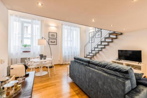 a living room with a couch and a staircase at Loft Crocetta in Turin