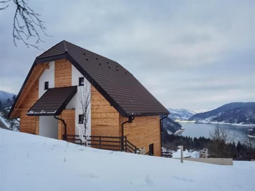 um edifício no topo de uma encosta coberta de neve em Villa Montana Zaovine em Bajina Bašta