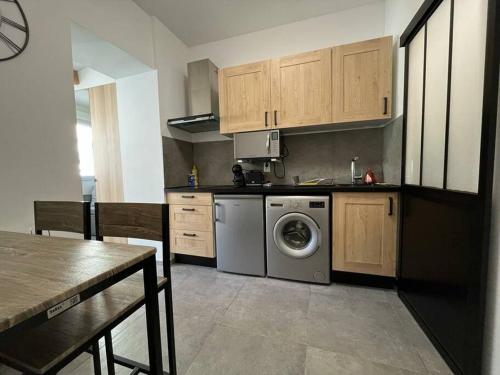 une cuisine avec une machine à laver et une table dans l'établissement Citronnier, à Marseille