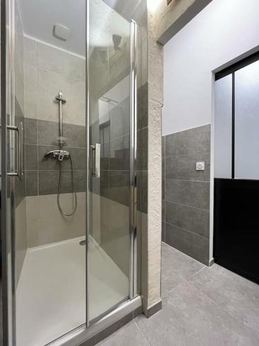 une douche avec une porte vitrée dans une salle de bain dans l'établissement Citronnier, à Marseille