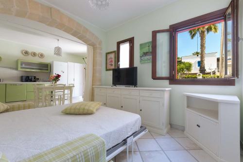a bedroom with a bed and a sink and a kitchen at Villa Ilaria Chiusurelle by BarbarHouse in Porto Cesareo