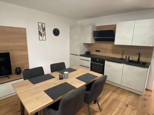 a kitchen with a wooden table and chairs in a room at Apartments Loim Lodge in Dürnstein