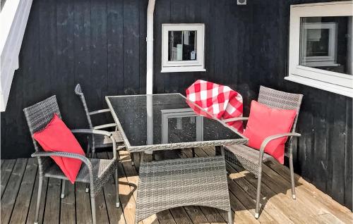 a table and chairs on a deck with red pillows at Beautiful Home In Nakskov With Sauna in Nakskov