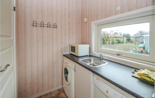 a kitchen with a sink and a microwave on a counter at Beautiful Home In Nakskov With Sauna in Nakskov