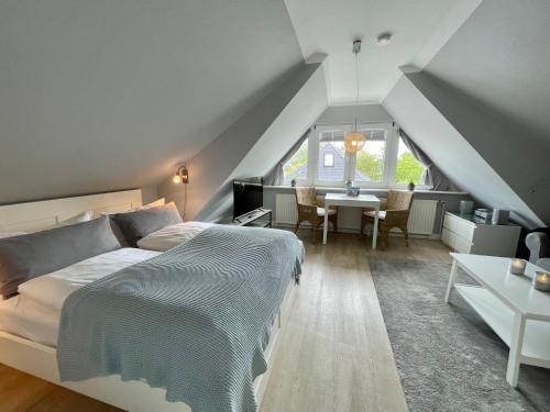a bedroom with a bed and a dining room with a table at Haus Eberhardt Appartement 2 in Tinnum