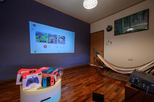 a room with a projection screen and some boxes at 隠れ宿ＴＯＭＡＲo in Motobu