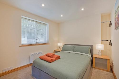 1 dormitorio con 1 cama, 2 lámparas y ventana en Tom's cabin en Knaresborough