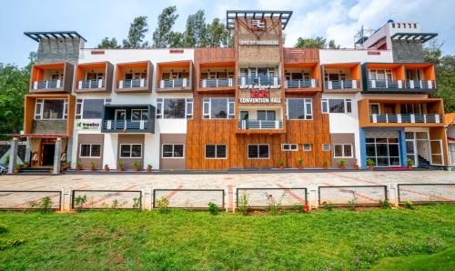 un grand bâtiment avec une clôture devant lui dans l'établissement Treebo Trend 3C Comforts, à Chikmagalur