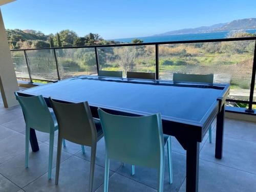 d'une table à manger et de chaises sur un balcon avec vue. dans l'établissement Spacieux appart- 6PERS- VUE MER- 2 min de la plage, à Propriano