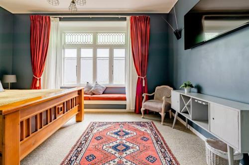 ein Schlafzimmer mit einem Bett und einem Fenster mit einem Fenstersitz in der Unterkunft Bavaria Boutique Hotel in Auckland