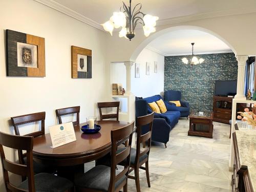ein Wohnzimmer mit einem Tisch und einem blauen Sofa in der Unterkunft Casa María Pilar in Cazorla
