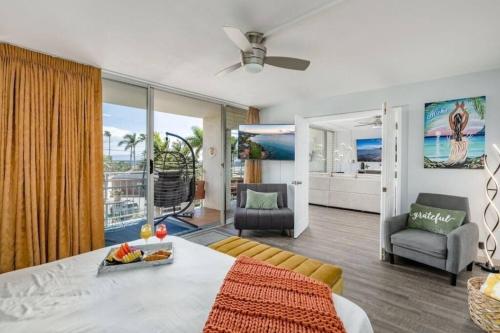 uma sala de estar com uma cama e uma sala de estar com uma varanda em Ocean front- Cozy Condo Prime Location in Kihei em Kihei