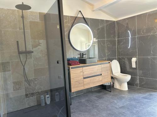 a bathroom with a sink and a toilet and a mirror at Chez Romain et Saphie in Les Baux-de-Provence