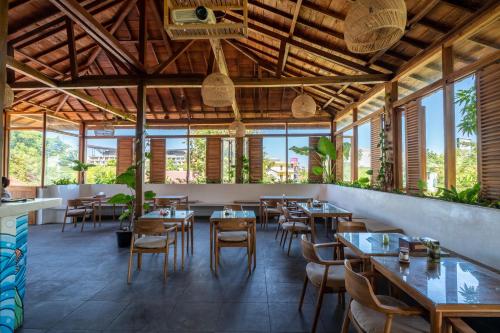 a restaurant with tables and chairs and windows at Dragon Dive Komodo Dive Resort in Labuan Bajo