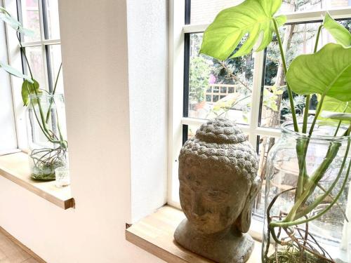 a vase sitting in front of a window with plants at Vidunderligt hus m/egen gårdhave - midt i centrum in Aalborg