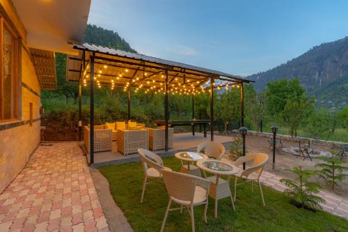 a patio with a table and chairs and lights at ArtBuzz Manali in Manāli