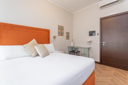 a bedroom with a large white bed with a wooden headboard at Daplace - Gran Torino Suites in Rome