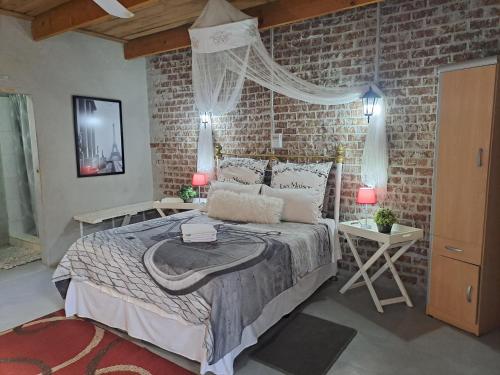 a bedroom with a bed and a brick wall at Shangrila-innibos Country Lodge in Hartbeespoort