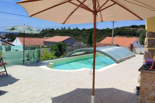 a large umbrella sitting next to a swimming pool at Kyrios Arts Atelier with use of private swimming pool in Carrascal