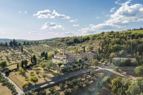 an aerial view of a villa in a valley with trees at Pieve Aldina Relais & Ch&acirc;teaux in Radda in Chianti