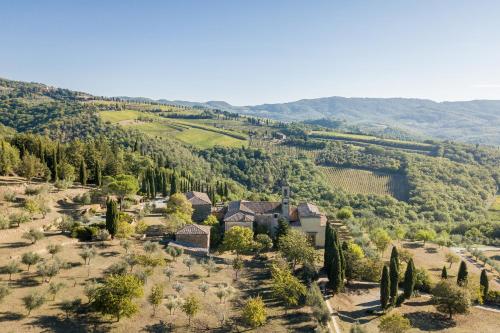 una vista aérea de una casa en un valle con árboles en Pieve Aldina Relais & Châteaux, en Radda in Chianti