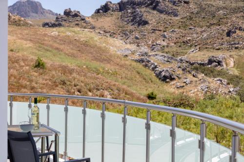 a balcony with a table and a view of a mountain at Nereides - Skinaria Beach Apartment in Damnoni