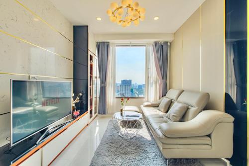 a living room with a couch and a tv at Grand SaiGon Centre - RiverGate Residence, Free Gym&Pool in Ho Chi Minh City