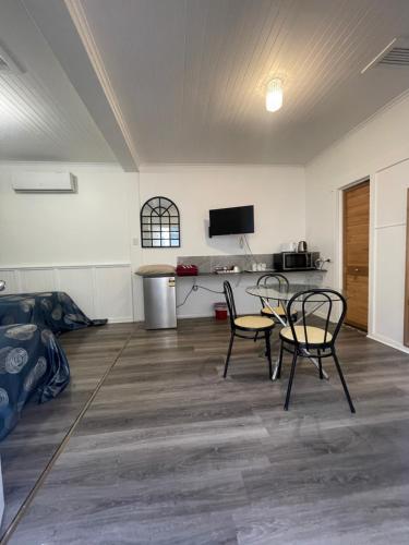 a room with two chairs and a table and a tv at Tamworth Lodge Motel in Tamworth