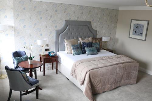 a bedroom with a bed and a table and a chair at Abbey Hotel Donegal in Donegal