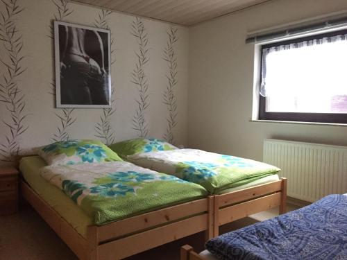 a bedroom with two beds and a window at Ferienwohnung-Schmidt-2 in Gelenau