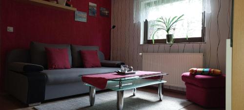 - un salon avec un canapé et une table dans l'établissement Ferienwohnung-Schmidt-2, à Gelenau