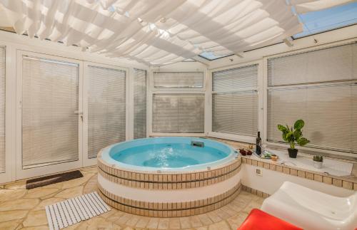 a hot tub in a room with windows at Holiday home Nika in Linardići