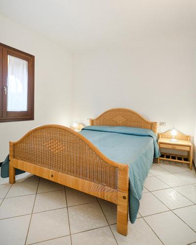 ein Schlafzimmer mit einem Holzbett mit einer blauen Decke in der Unterkunft AMBRA Holiday Rooms in San Teodoro