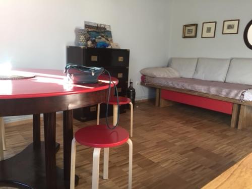 a living room with a red table and chairs and a couch at Due Delfini Apartment in Venice