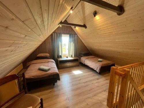 a attic room with two beds and a staircase at Vahtra allee külalismaja 