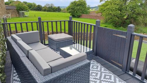a patio with a bench and a fence at Coastal Cottage, Private Hot Tub & Sauna Sleeps 2-8 with Views in Skelton