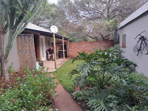 a man sitting in the doorway of a house at Shangrila-innibos Country Lodge in Hartbeespoort