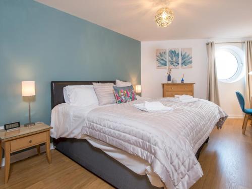 a bedroom with a large bed and a table at Pass the Keys Lovely 2 Bedroom Apartment in the Bay with a view in Cardiff