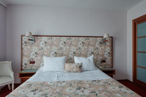 a bedroom with a large bed with a floral headboard at Ramblas Vendrell in El Vendrell