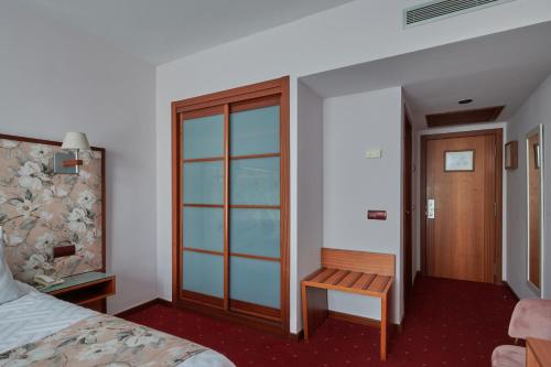 a hotel room with a bed and a wooden bench at Ramblas Vendrell in El Vendrell
