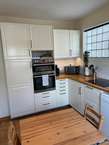 une cuisine avec des armoires blanches et un four à plaques de cuisson dans l'établissement « Le refuge » charmant,proche zoo et centre ville, à Saint-Aignan