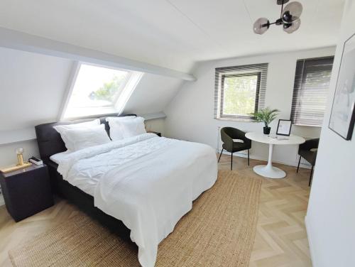 - une chambre avec un grand lit blanc et un bureau dans l'établissement Guesthouse at the Amstel river with 2BR 2BA and garden, à Amstelveen