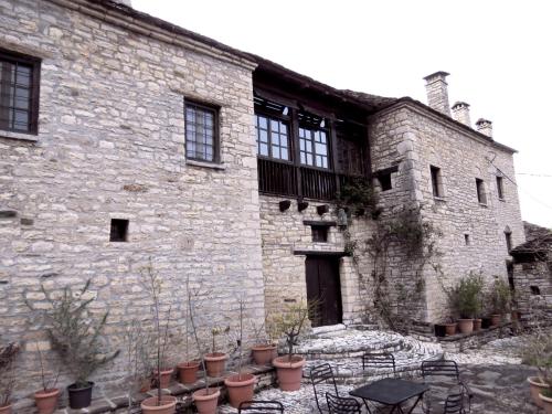 a stone building with potted plants in front of it at Arhontiko Aristis in Aristi