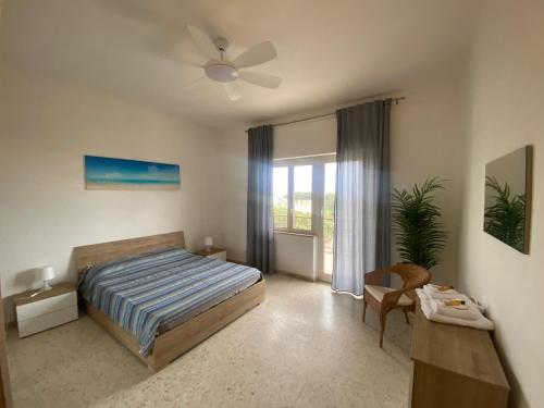 a bedroom with a bed and a ceiling fan at APPARTAMENTO CENTRALE SANTA MARINELLA in Santa Marinella