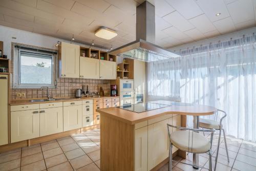 a kitchen with white cabinets and a counter with stools at Holiday home Nika in Linardići