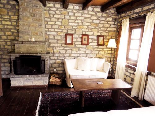 a living room with a couch and a fireplace at Arhontiko Aristis in Aristi